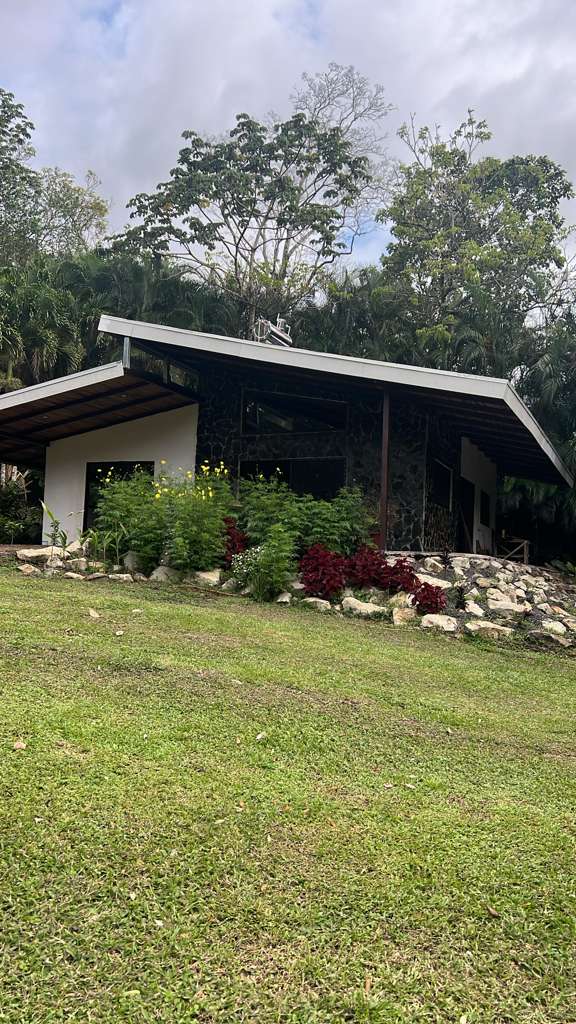 Tropical home exterior with natural stonework and garden